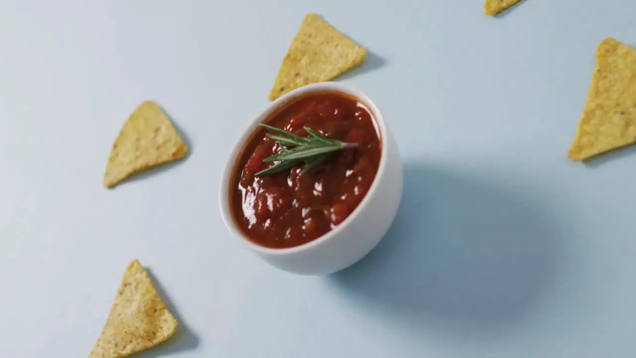 Video of tortilla chips and salsa dip on a grey surface