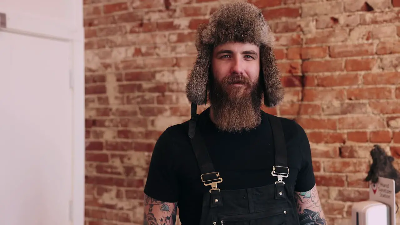 Bearded Man With Fur Hat Authentic Portrait Smiling Crossing Arms Small Town Friendly Tattoo Burly Rough