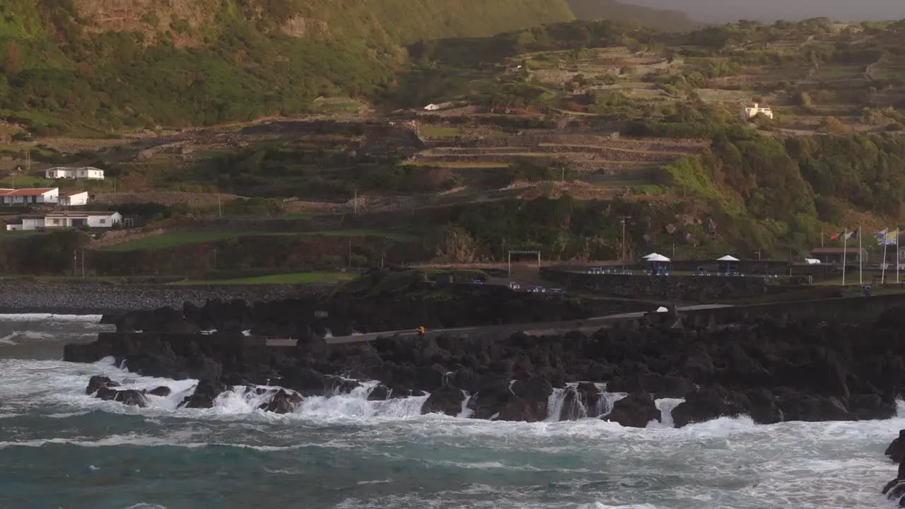 Side panning shot of rough ocean with big waves hitting rough coastline aerial