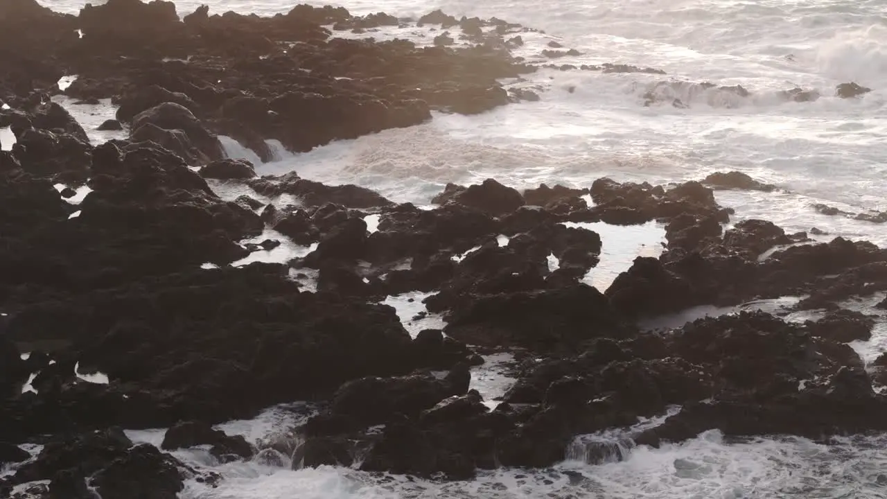 Wave crashing into the rocky coastline at Flores island aerial