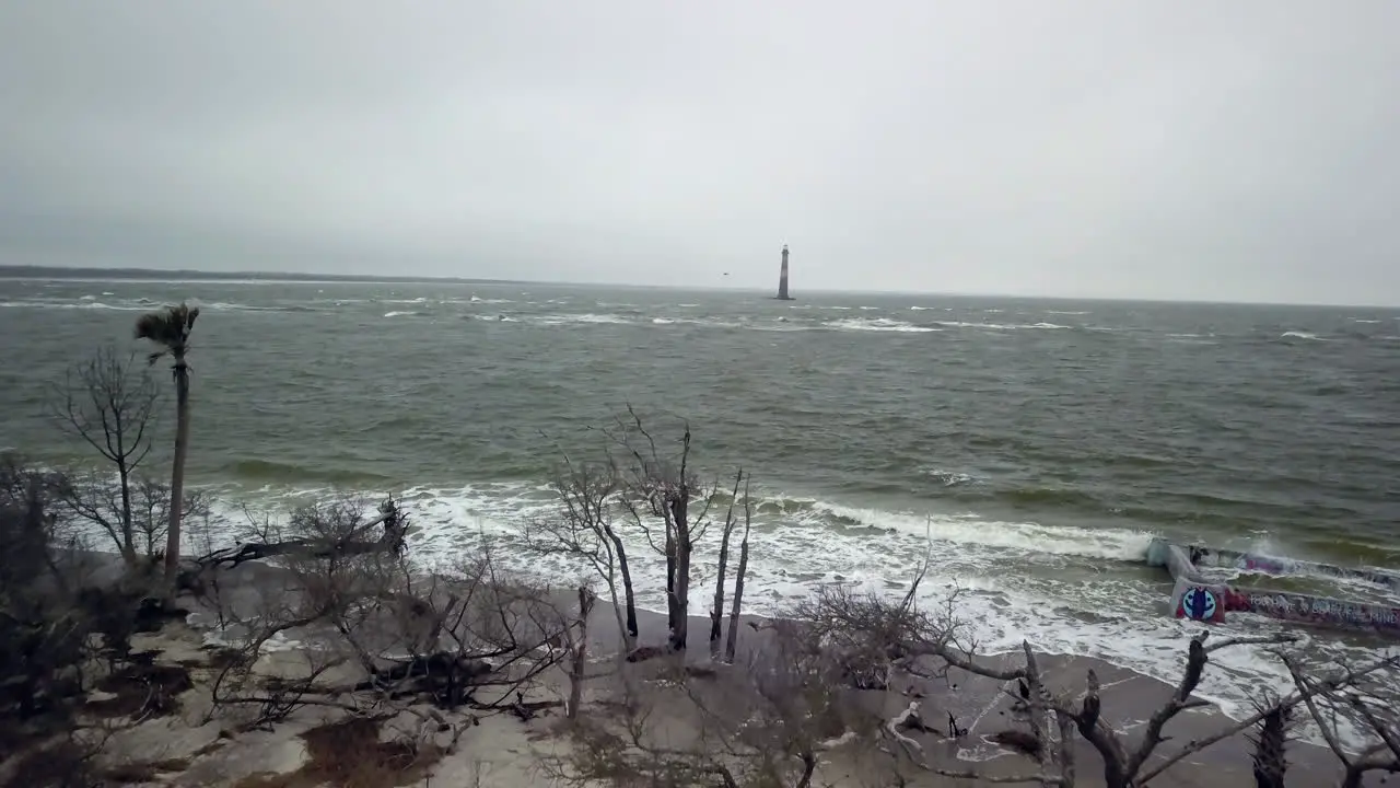 Aerial of Morris Island Lighthouse in the distance with Folly Beach and the Atlantic Ocean in the foreground