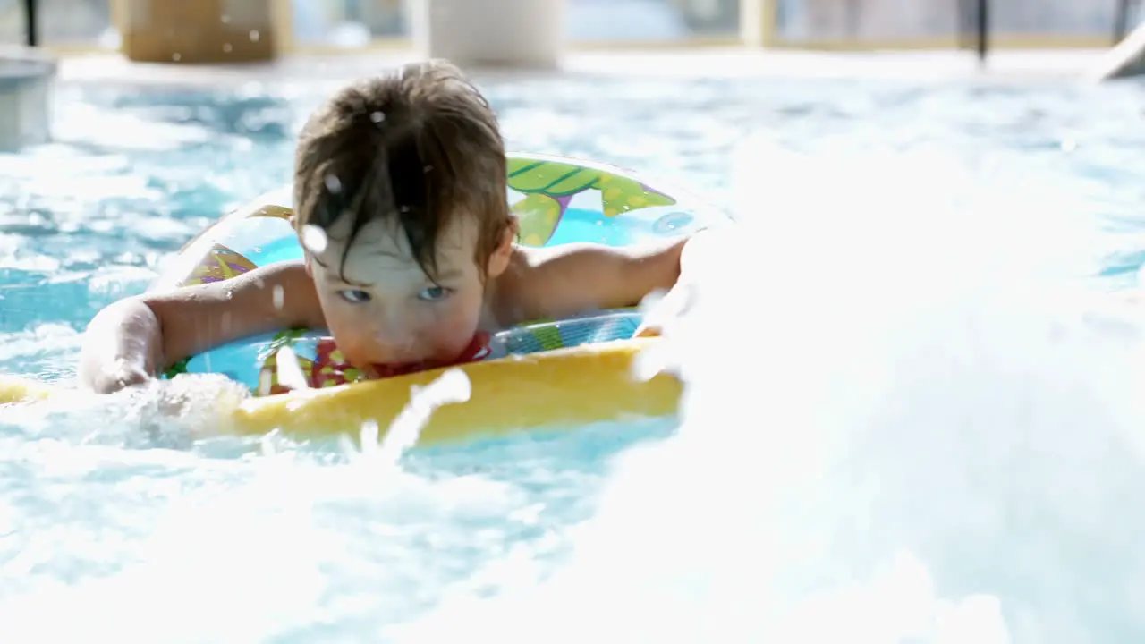 Little boy swimming in the pool with rubber ring