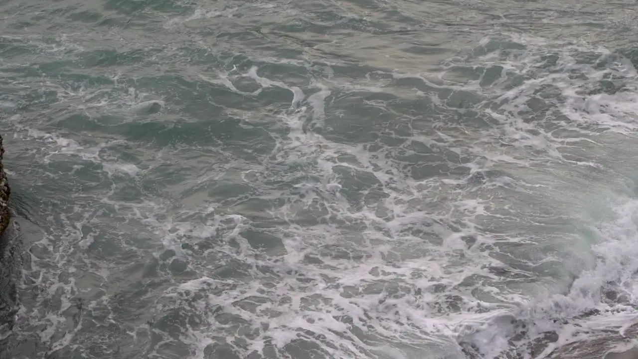 Swell at gray sea with white foam in slow motion