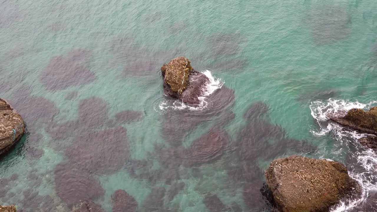 Looking down at shallow ocean waters with rocks sticking out