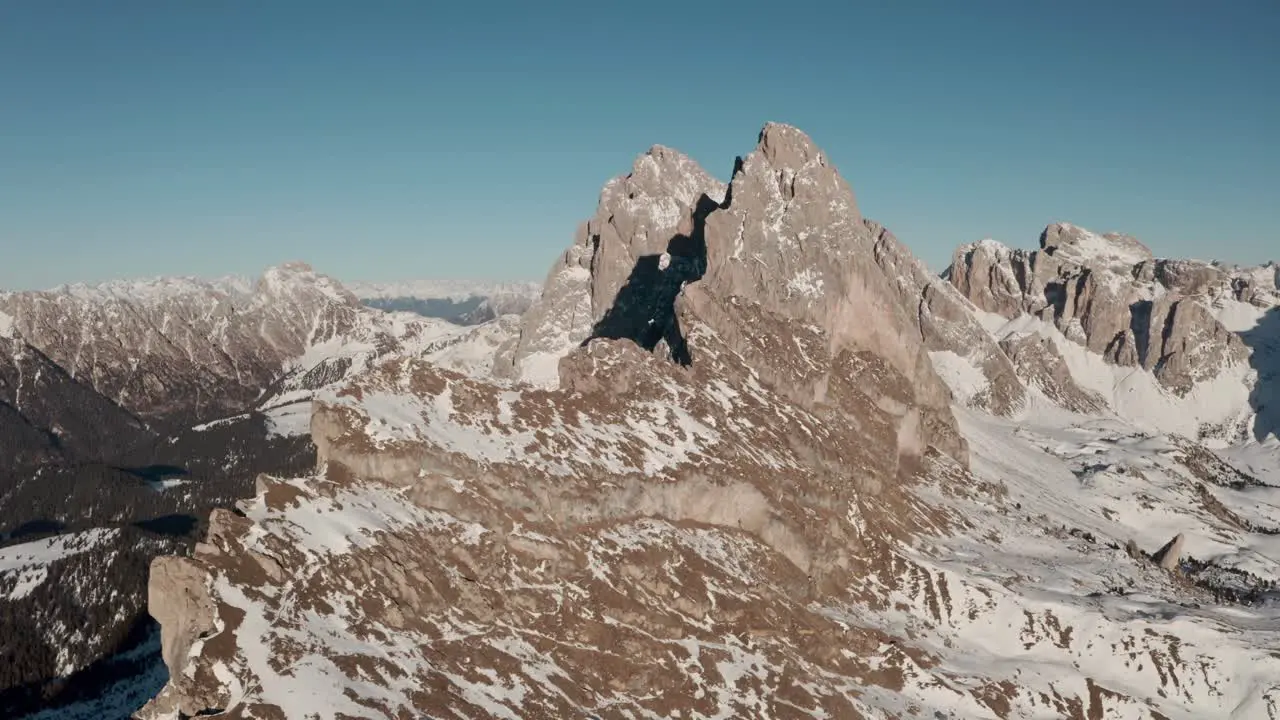 Slow dolly back drone shot over impressive mountain ridge