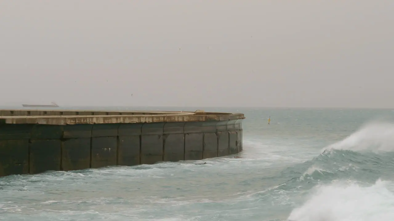 Rough ocean with waves crushing on breakwater