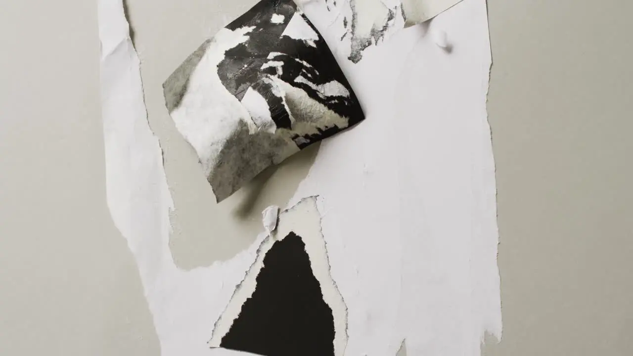 Video of close up of torn leyers of paper on white background