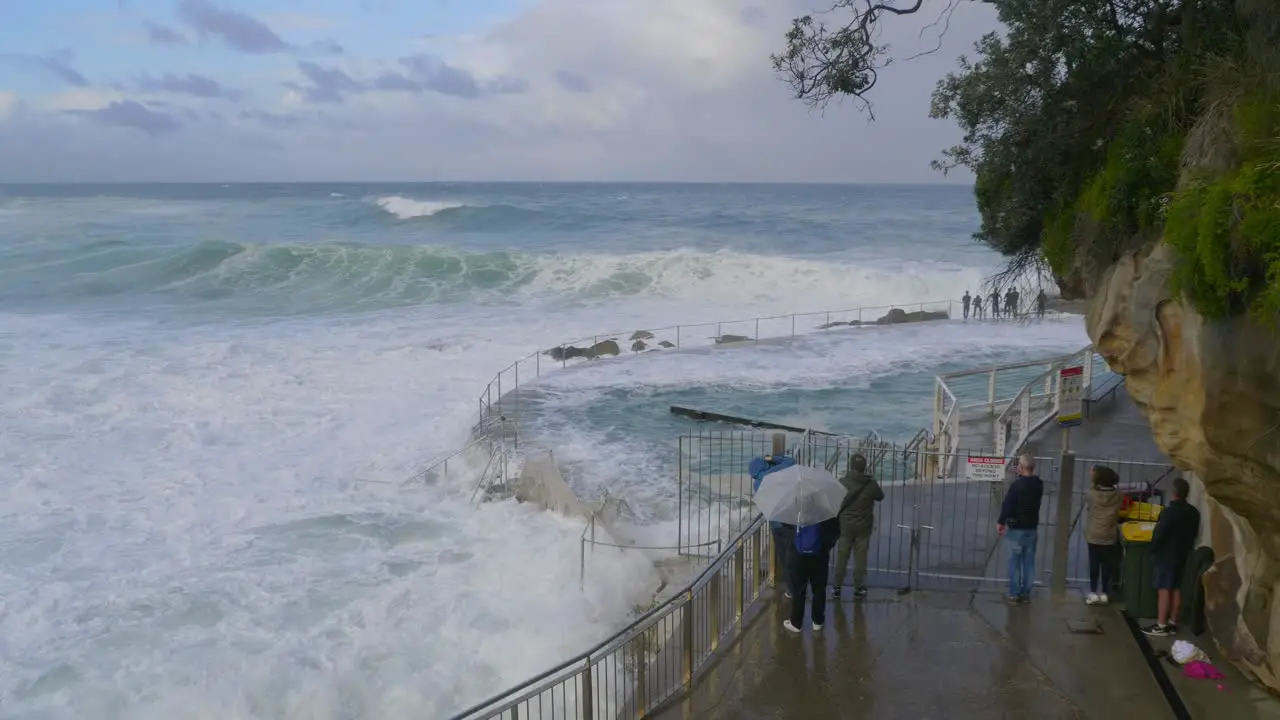 People Watching The Rough Waves During Storm Overflowing Water From Bronte Baths Sydney NSW Australia