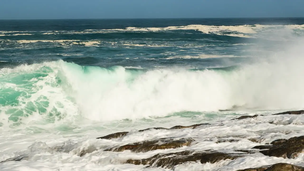 Wave collides dramatically on rocky shore big splash