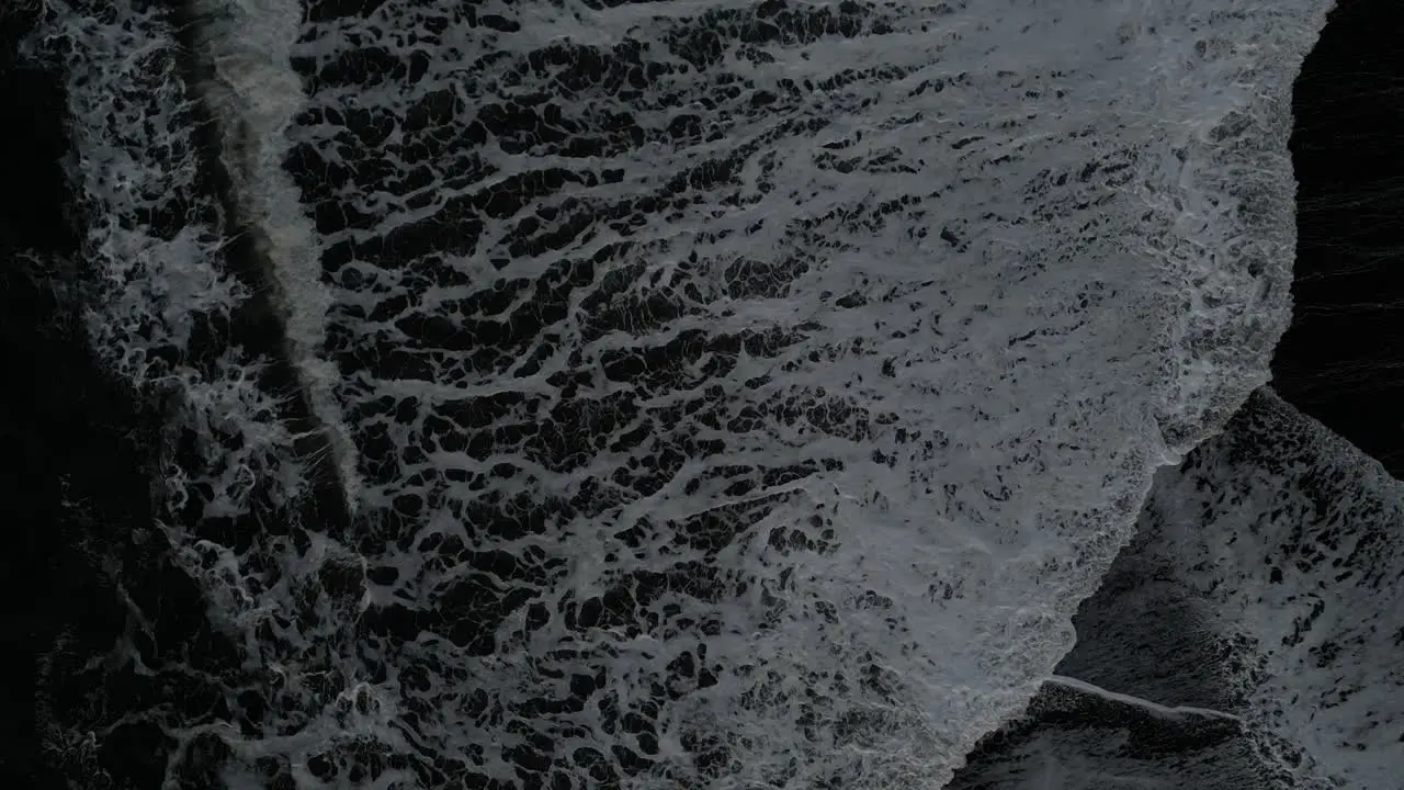 Birds Eye view of the waves coming in at Reynisfjara in Iceland aerial