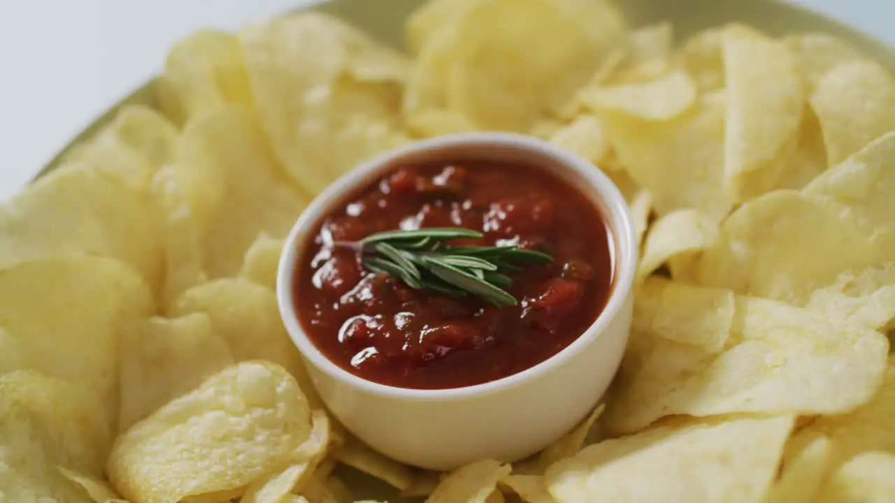 Video of crisps and salsa dip on a grey surface