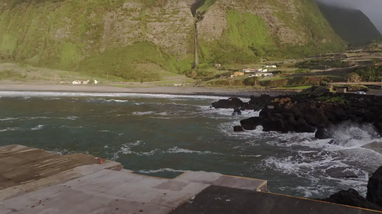 Photographer in yellow jacket near rough sea at Azores island aerial