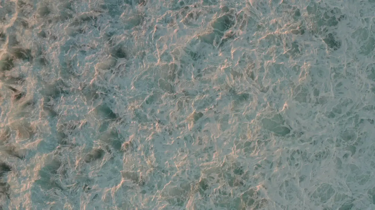 Low top down aerial shot over waves