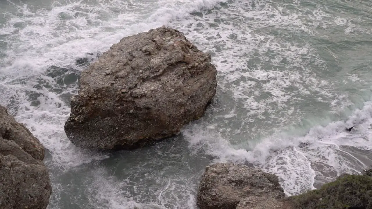 Looking down towards rocks and ocean in ocean during rogh sea