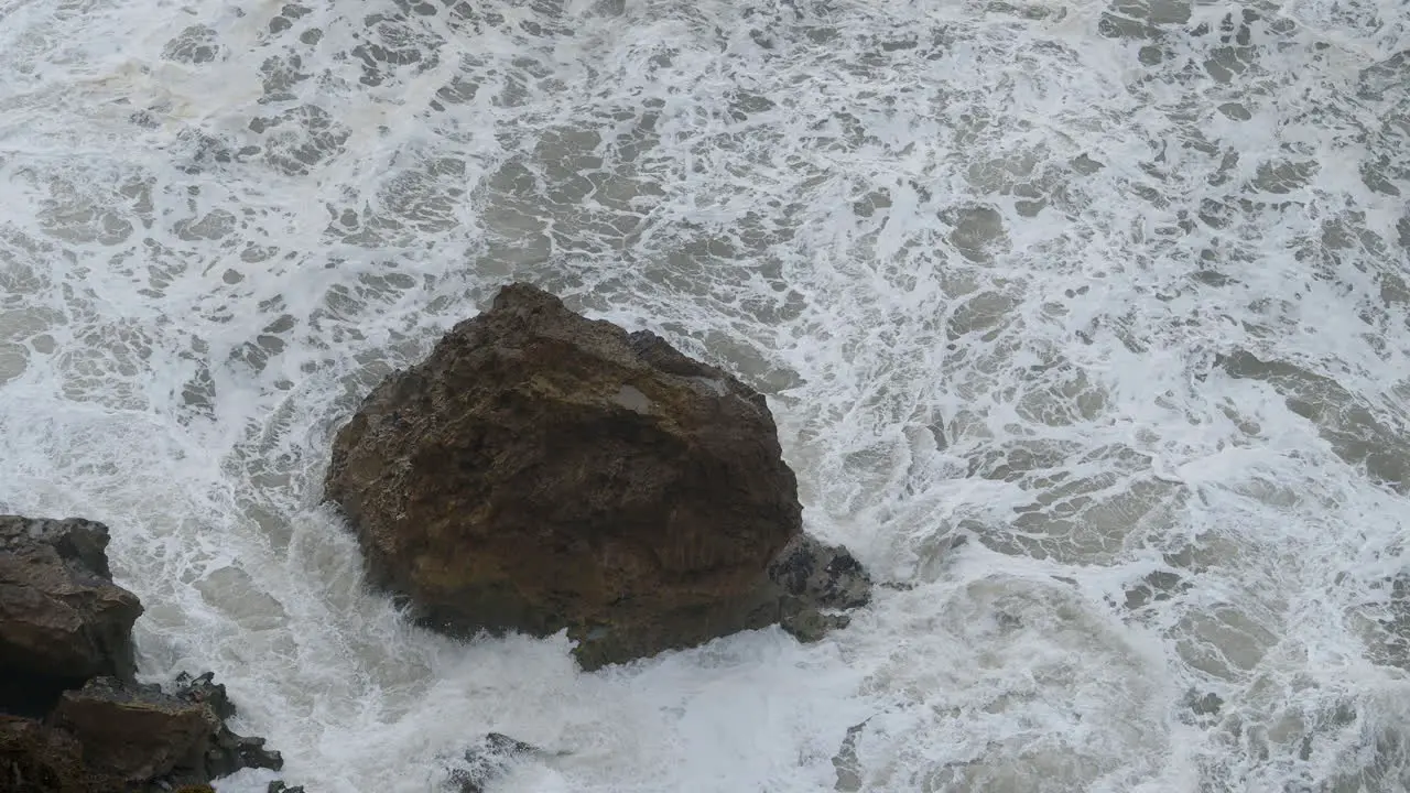 Foamy ocean water and big coastal rocks