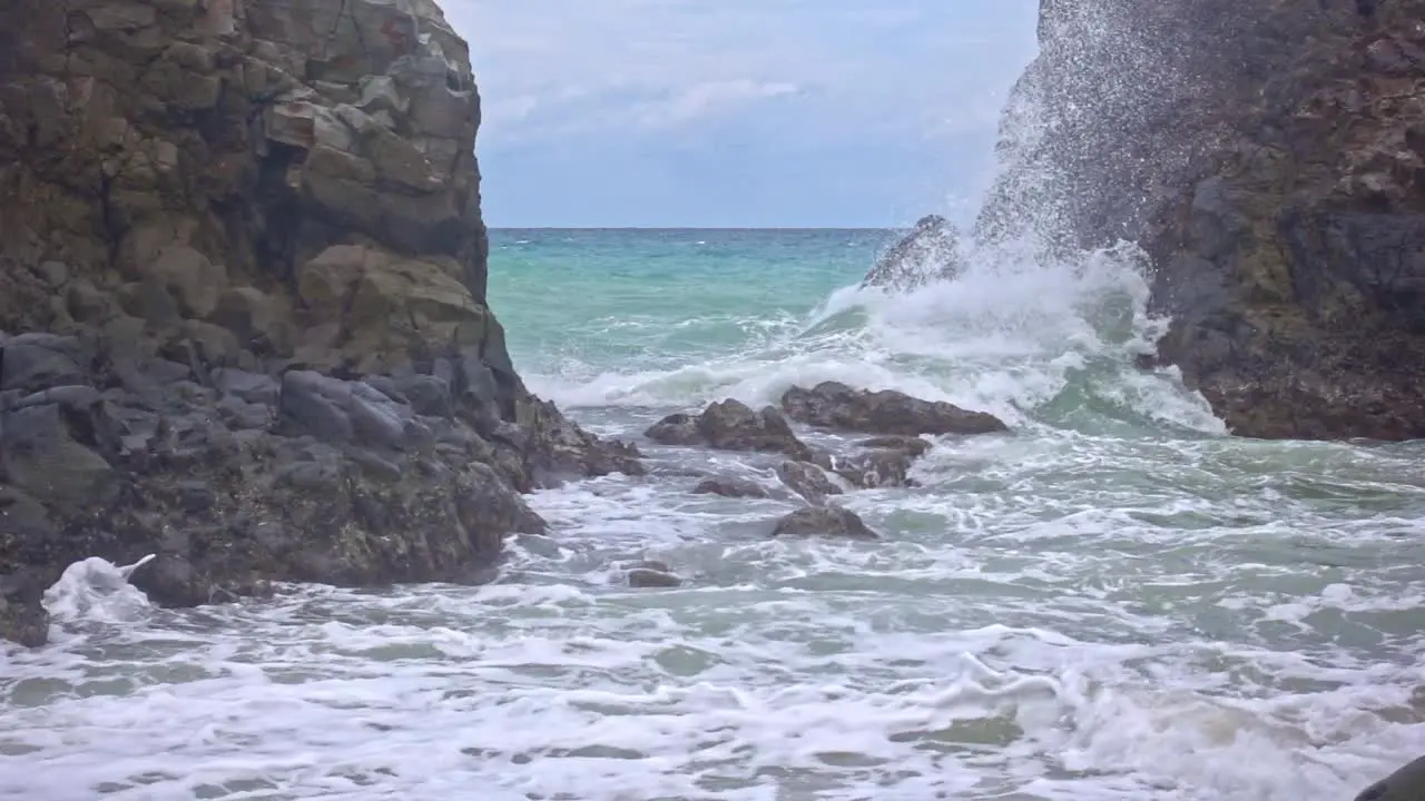 Static shot of white waves crashing into the rocky coastline of Banbanon Beach Surigao Del Norte Philippines