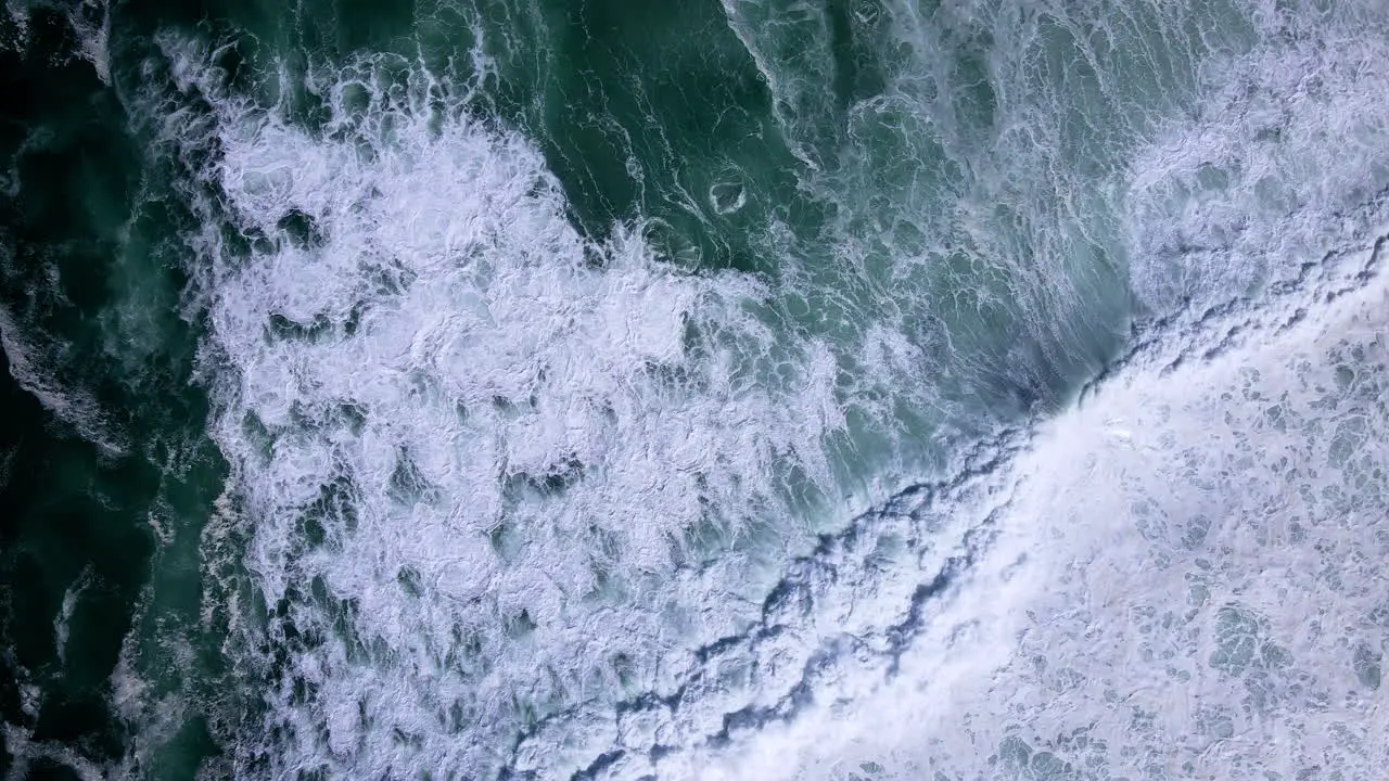 Big swell crash and runs out onto rocky coastline