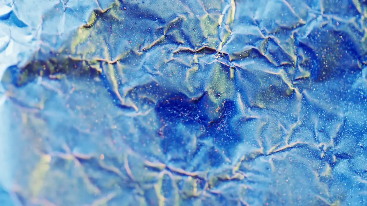 Close up of blue crumpled piece of paper in slow motion