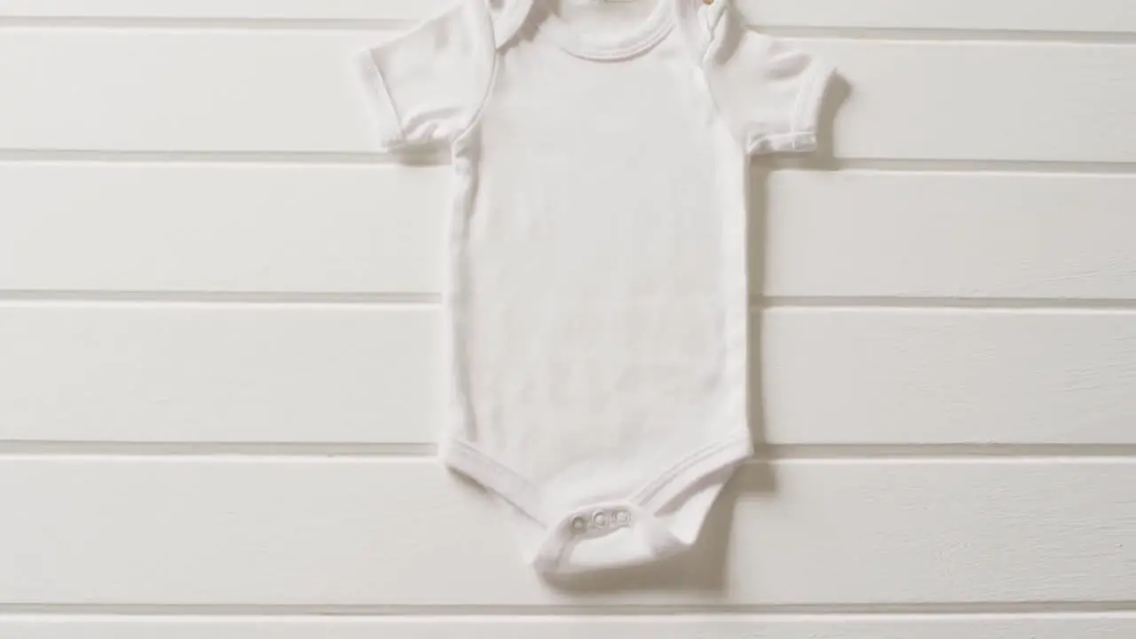 Video of close up of white baby grow on white background