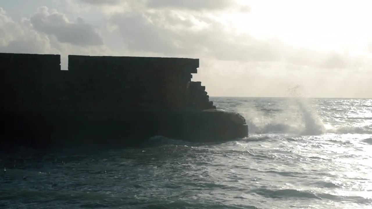 Ancient stone wall and wavy sea Acre Israel