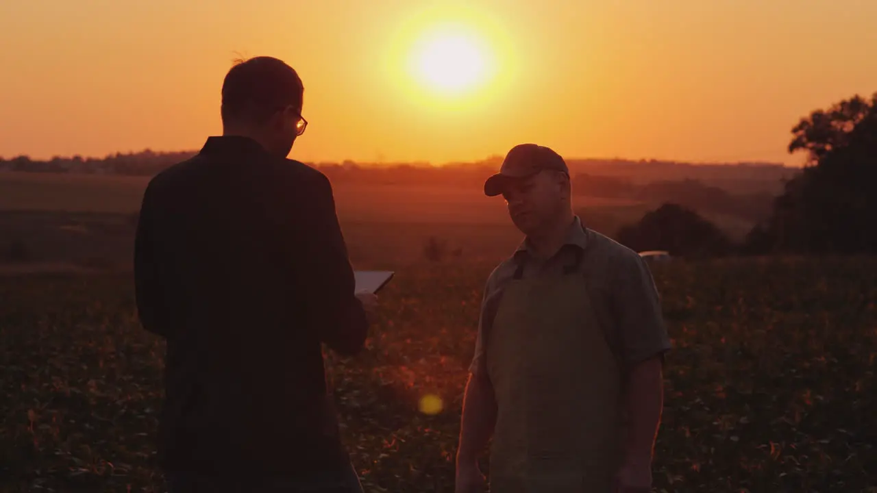 A Young Businessman Communicates With A Farmer In The Field