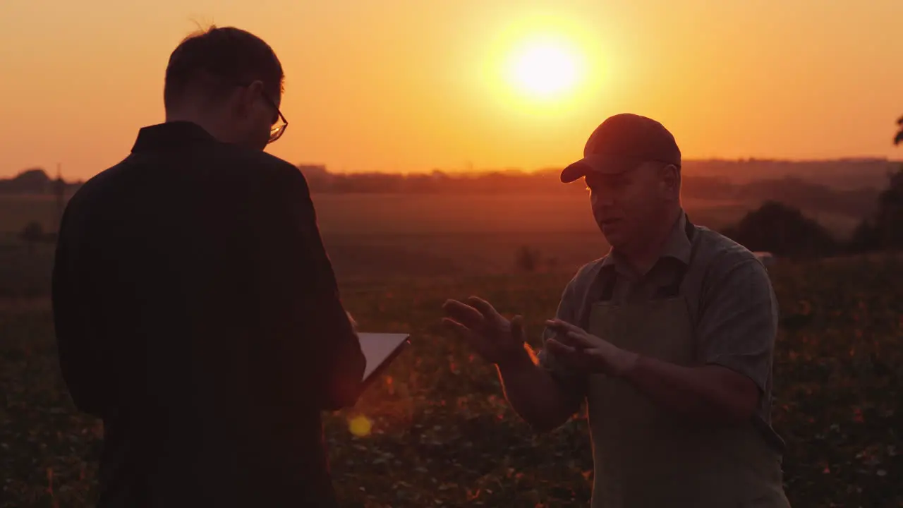 Farmer Discussing With A Businessman In A Field