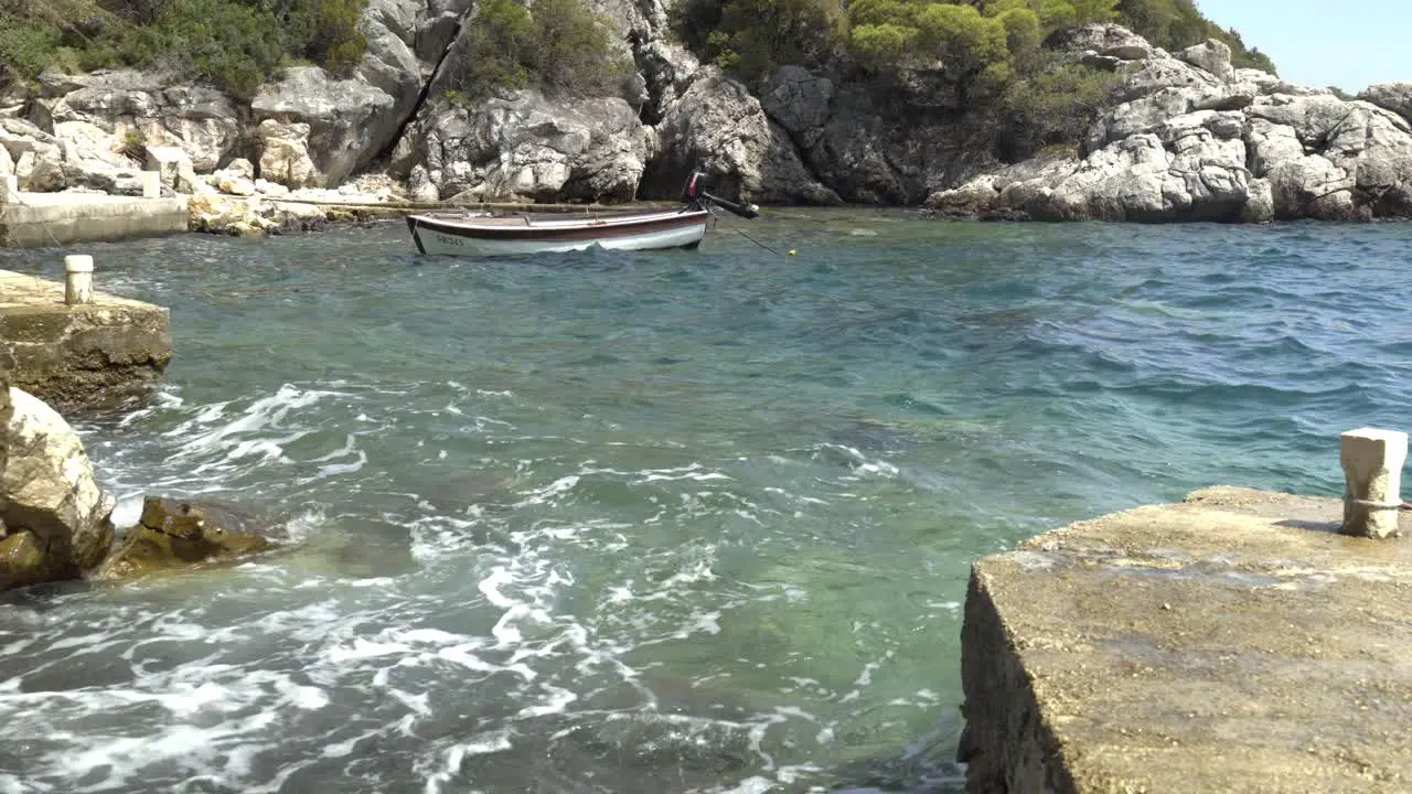 A lone boat in an alcove on Mljet Island Croatia rocking in the waves in the Adriatic Sea