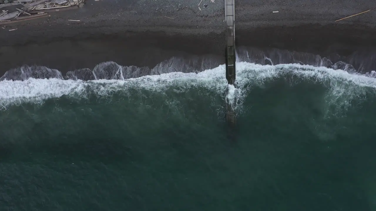 Slow aerial zoom out of waves crashing on the beach