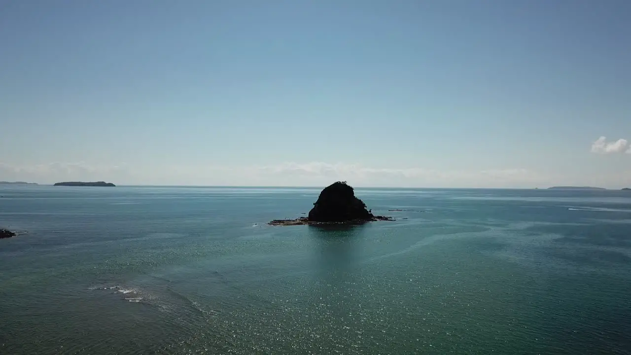 Island in the ocean at bay of islands New zealand with a speedboat in the background