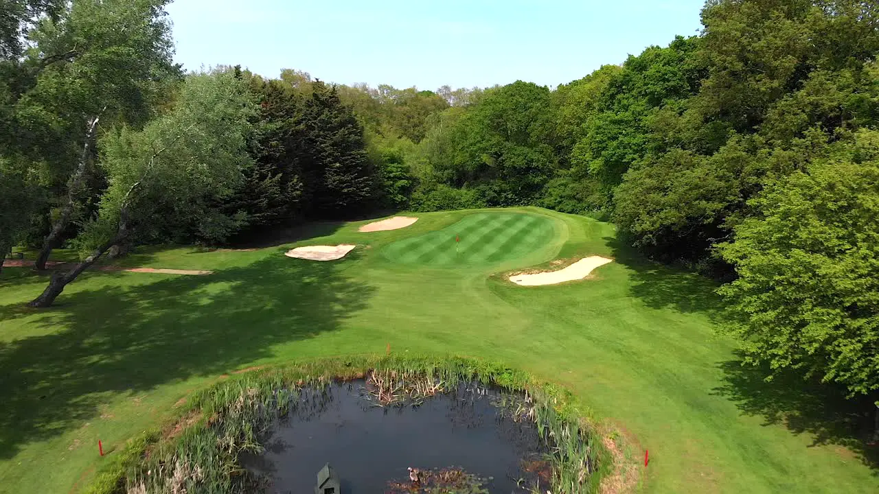 Smooth Aerial Flyover of English Golf Putting Green Bunker and Pond