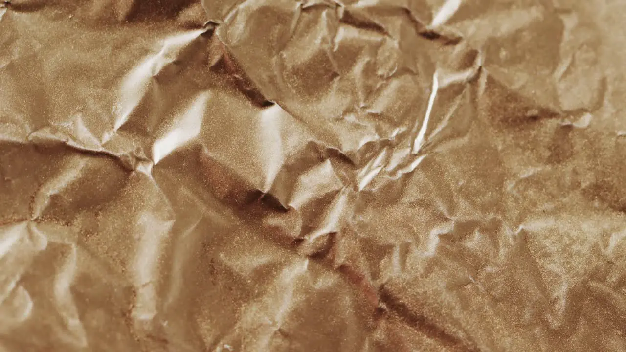 Close up of brown crumpled piece of paper in slow motion