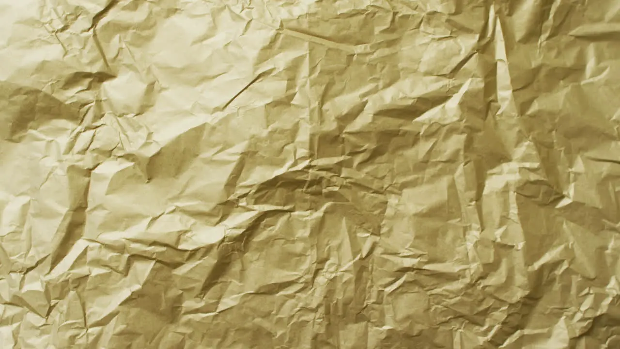 Video of close up of crumpled yellow paper texture background