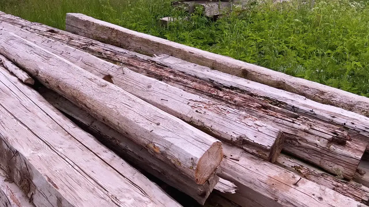 A stack of folded dry chopped wood logs in the field panning closeup