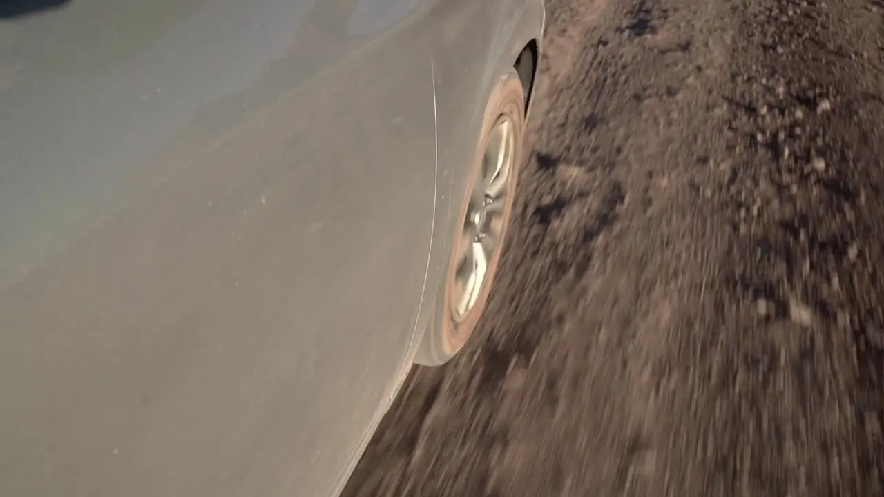 Car wheel riding along a desert sand road