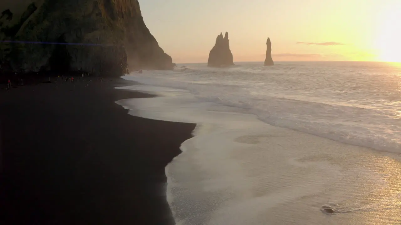 Slider drone shot over black sand beach and Columnes Reynisfjara Iceland