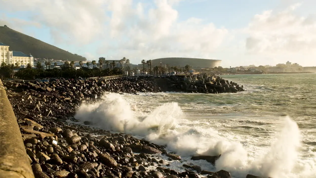 Waves crash on black rocky beach at Cape Town Waterfront