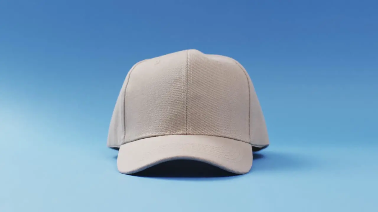 Video of beige baseball cap and copy space on blue background