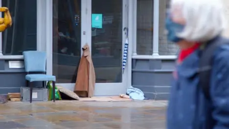 Long Shot of Homeless Persons Belongings In Disused Shop Entrance