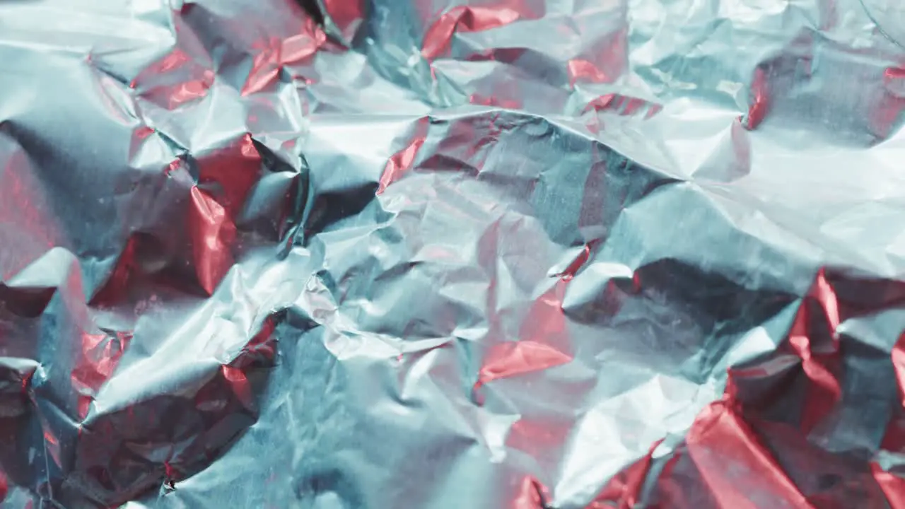 Close up of gray crumpled pieces of plastic material in slow motion