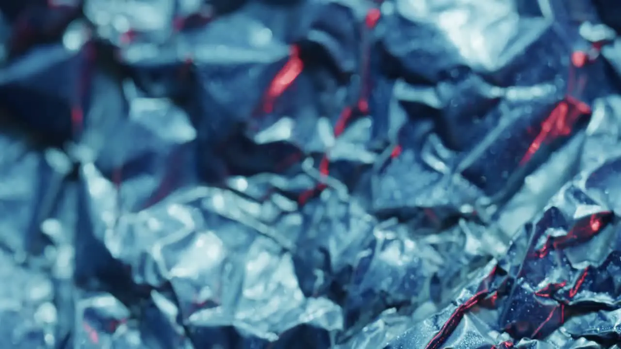 Close up of blue crumpled pieces of plastic material in slow motion