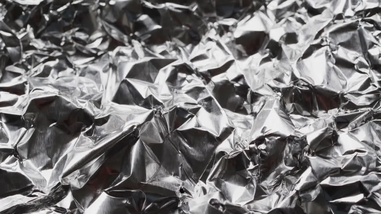 Close up of silver crumpled shiny aluminium in slow motion