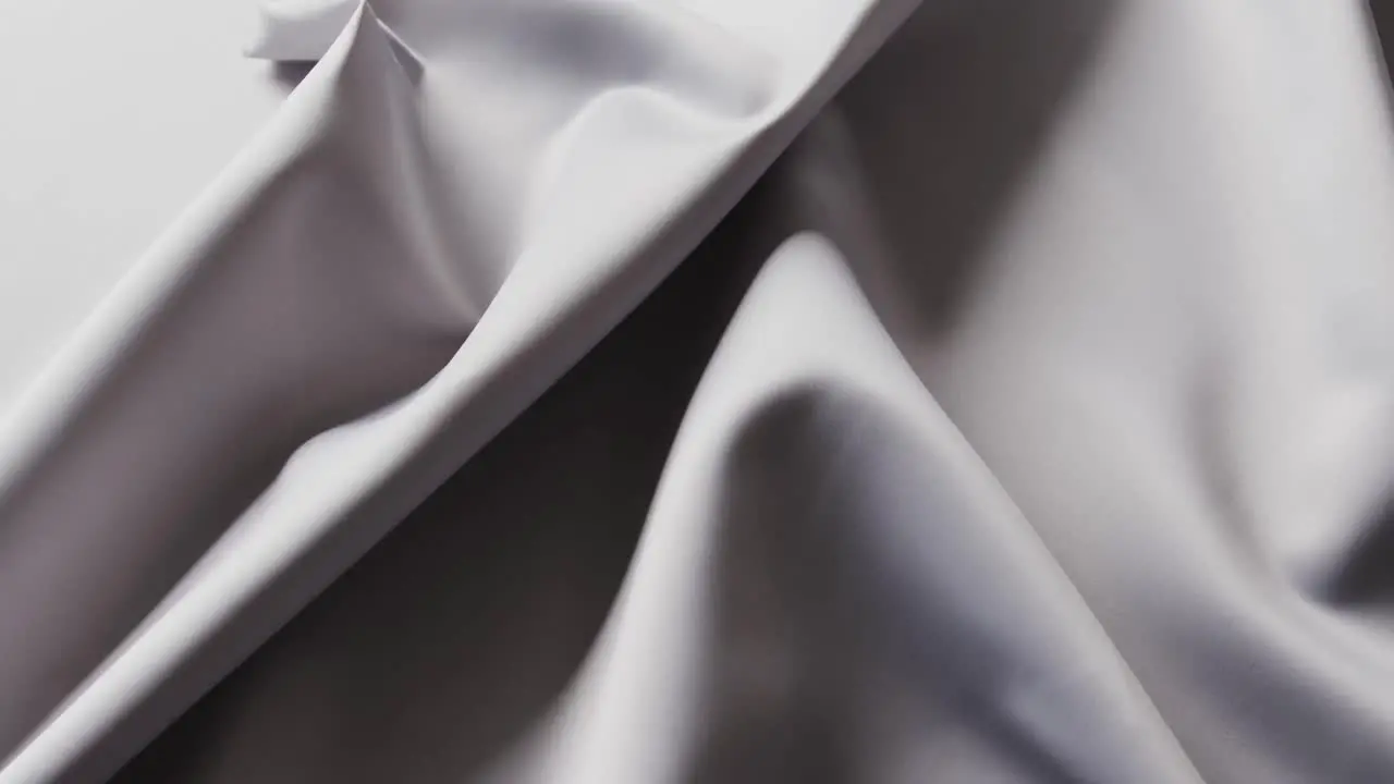 Close up of gray shiny silk cloth in slow motion