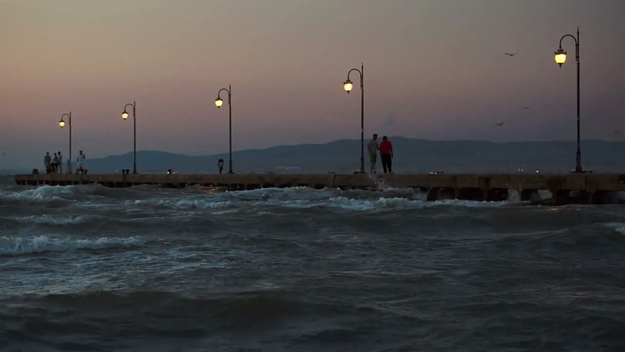 People on pier in the windy evening