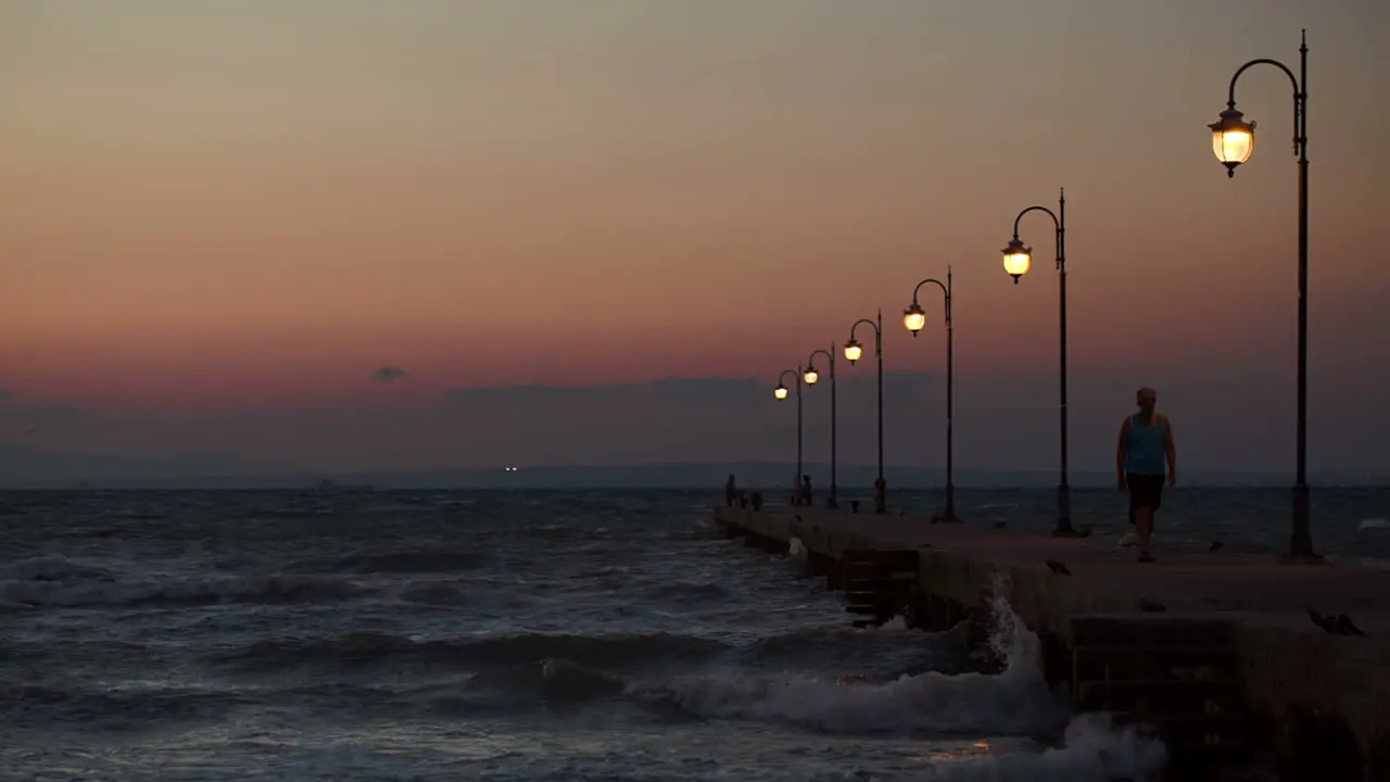 People walking and stading on pier in the evening