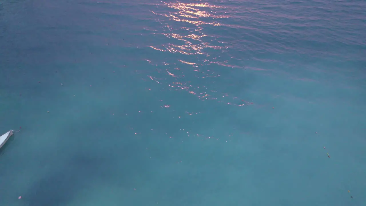 Slow aerial tilt up of turquoise waters to picturesque sunset on Ionian Sea coast