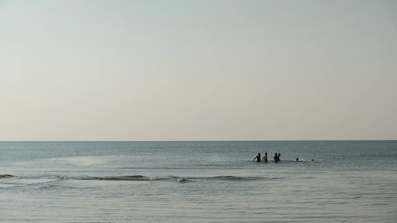 Silhouette of group young men playing water volleyball in the sea