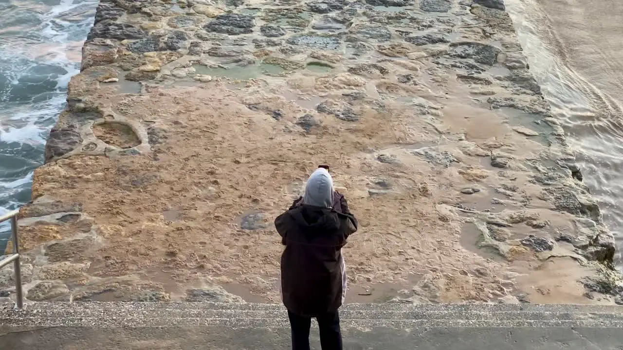 zoom in of Young man doing some photos of huge sunset on the beach