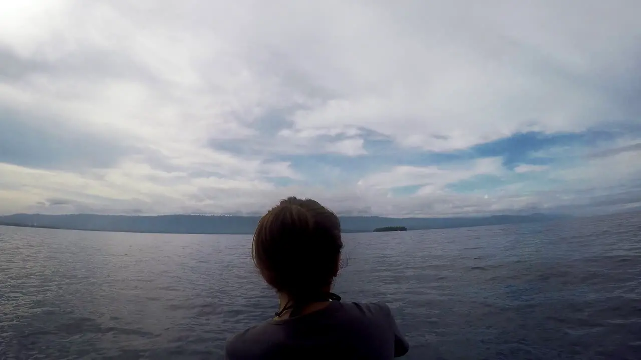 Woman Riding On Front Of A Boat During A Gloomy Weather