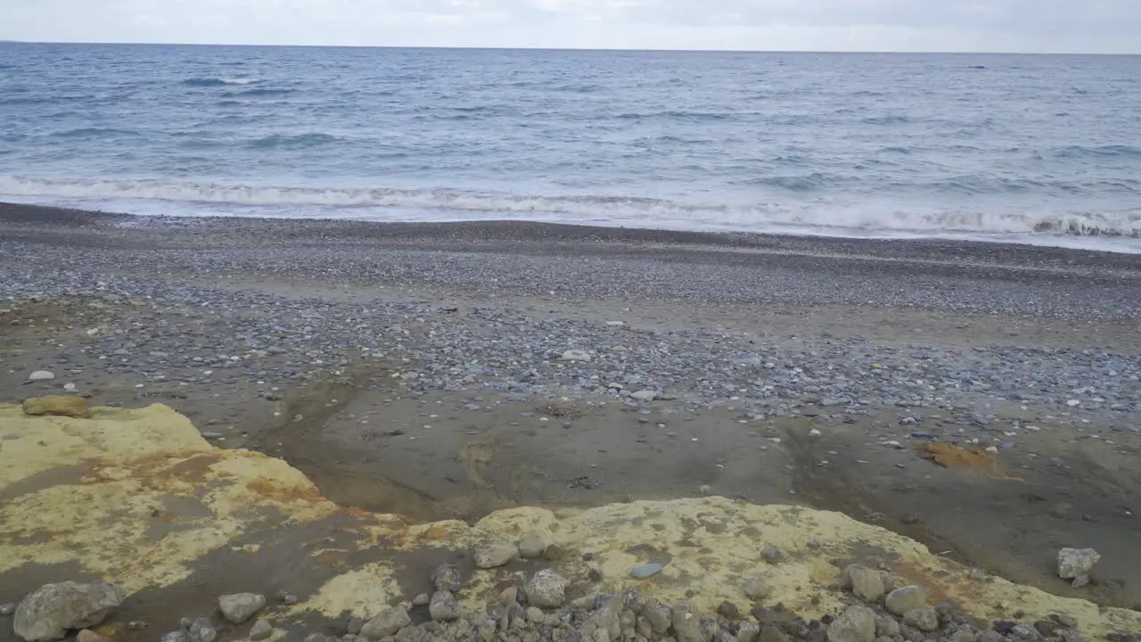 View of waves lapping on the beach covered in extractive waste