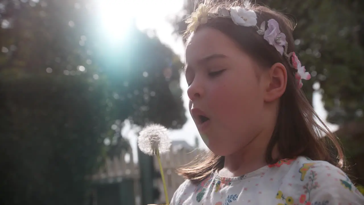 Young girl blows dandeline with flowers in her hair 1000 fps Phantom